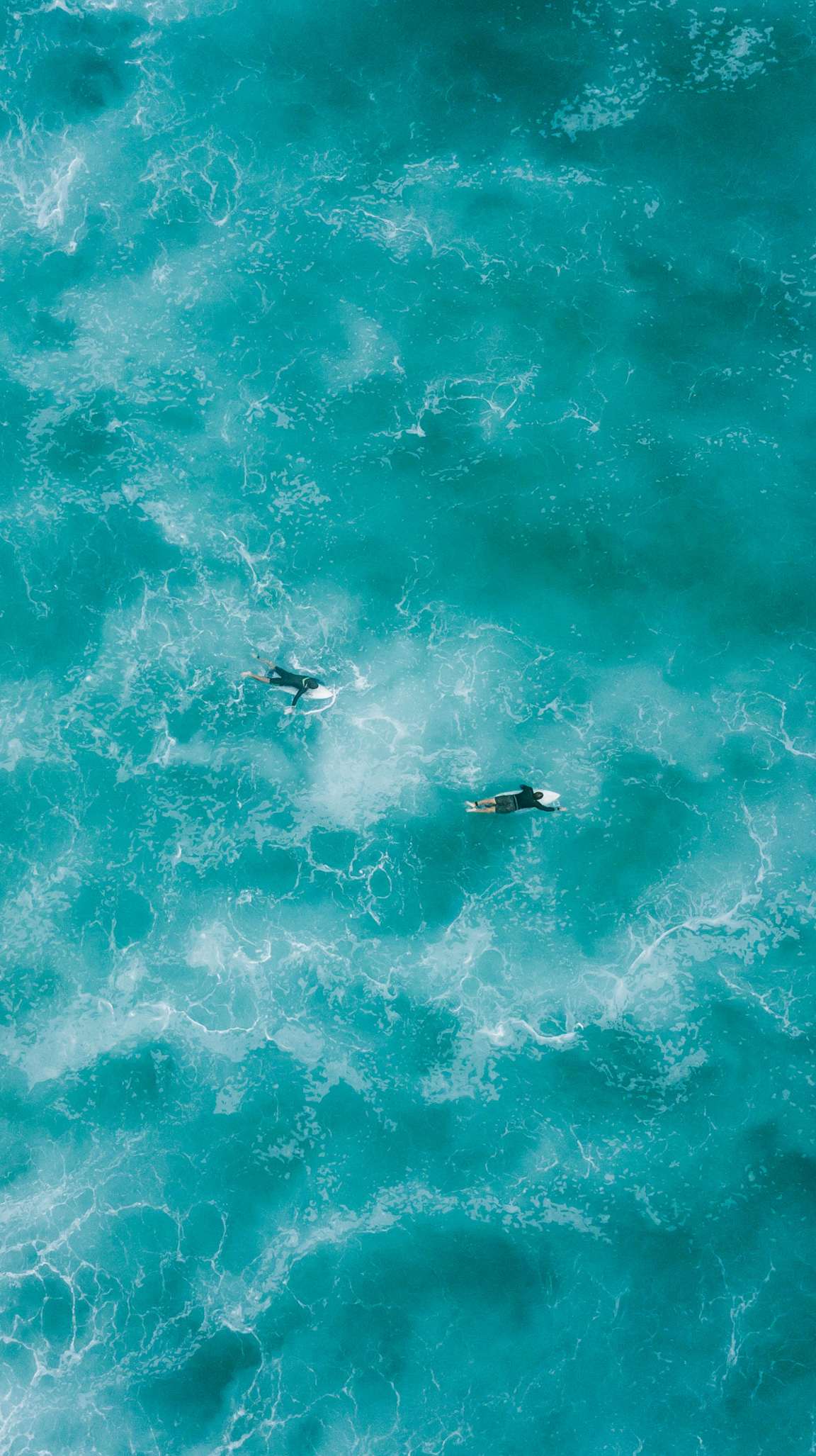 在蔚蓝的海上冲浪的冲浪爱好者航拍