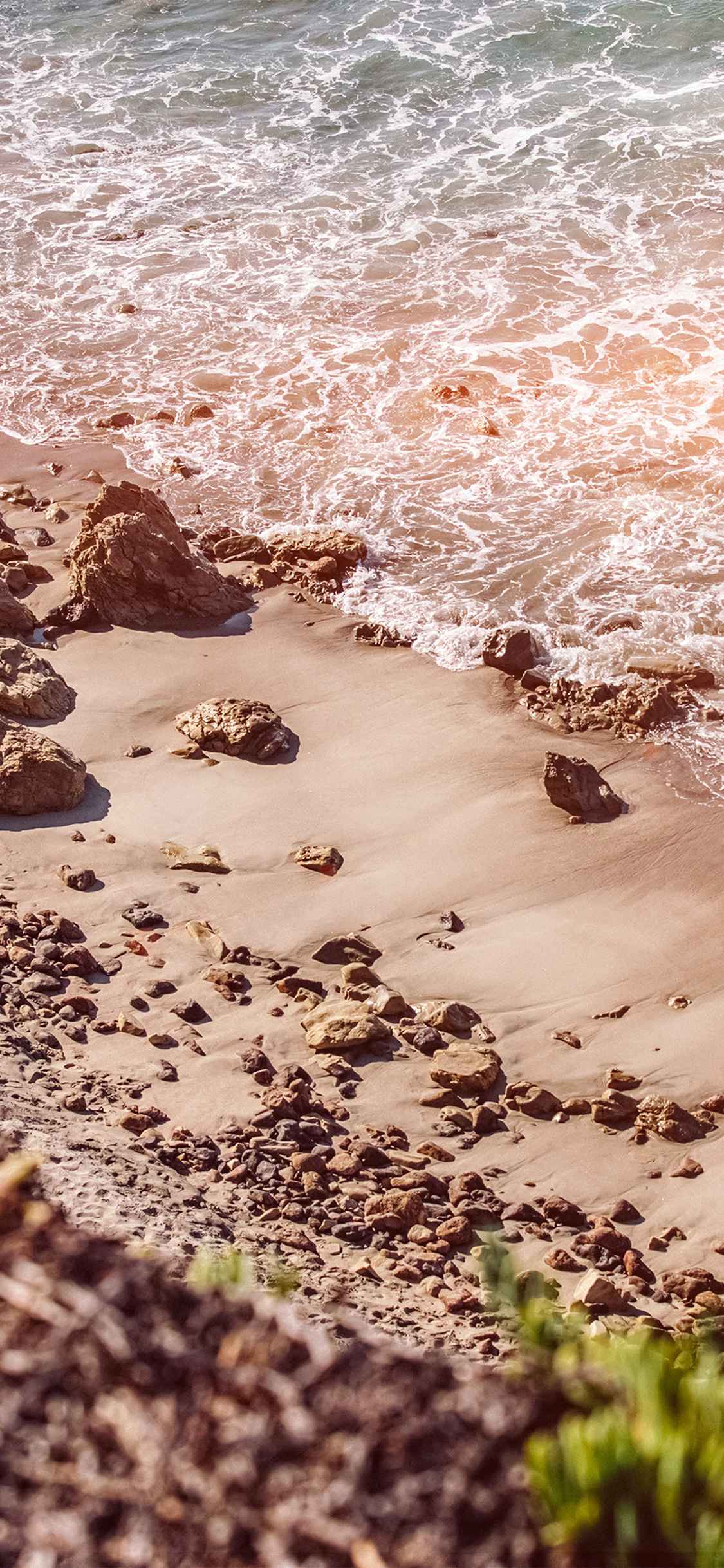 海边沙滩上的礁石摄影手机壁纸